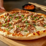 A crispy Chinese pizza with hoisin sauce, cheese, and scallions.